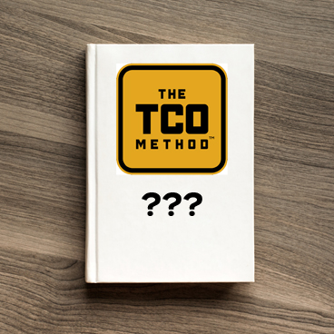 A book with the TCO Method logo and some question marks on a desk